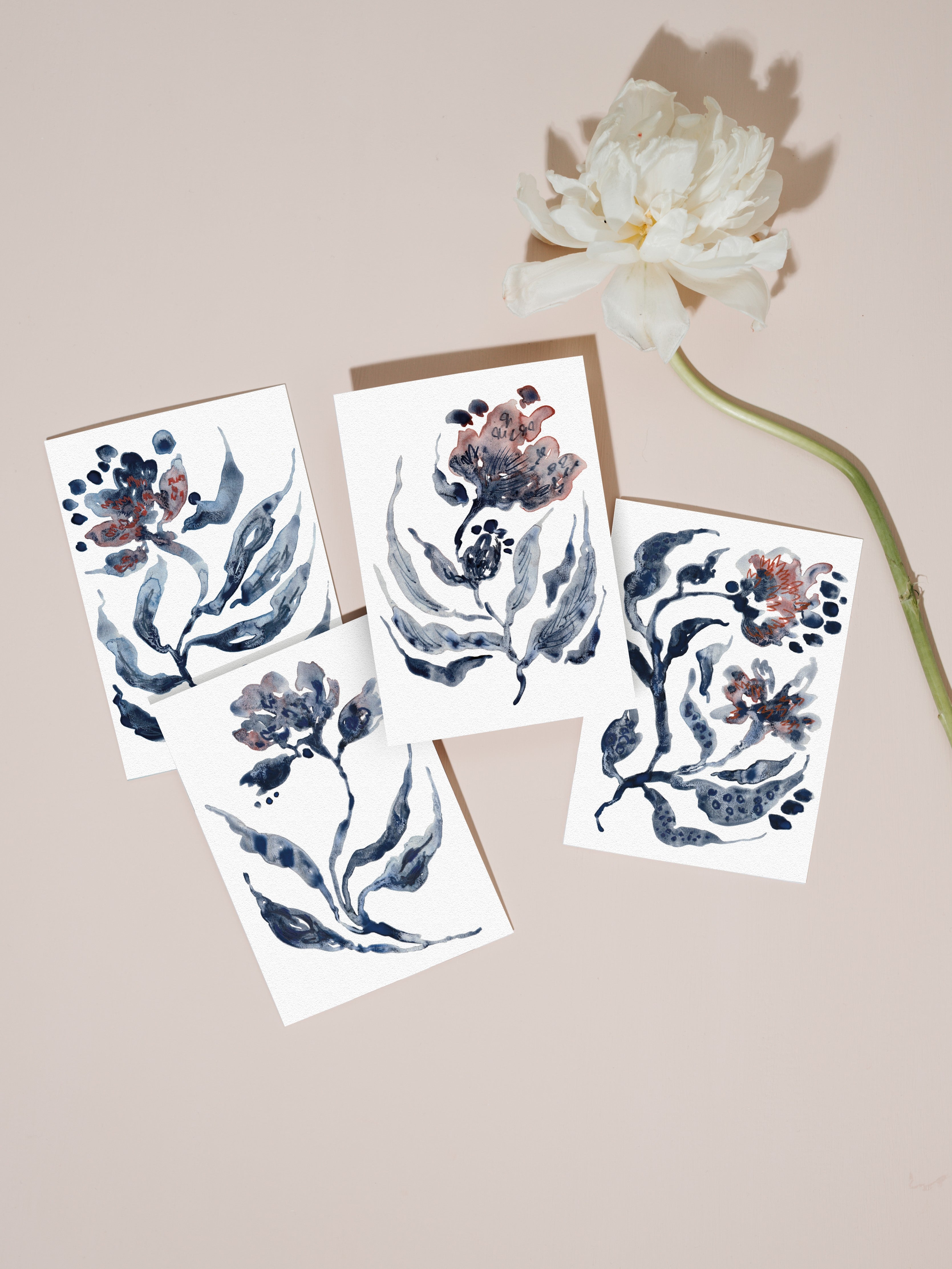 Set of floral greetings cards with a white flower on a pale pink background.