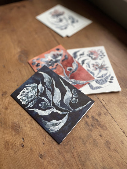 Floral greetings cards on a wooden surface.