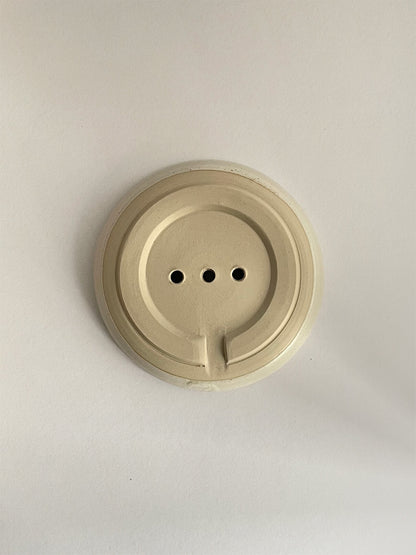 Ceramic soap dish on a neutral background - base view.