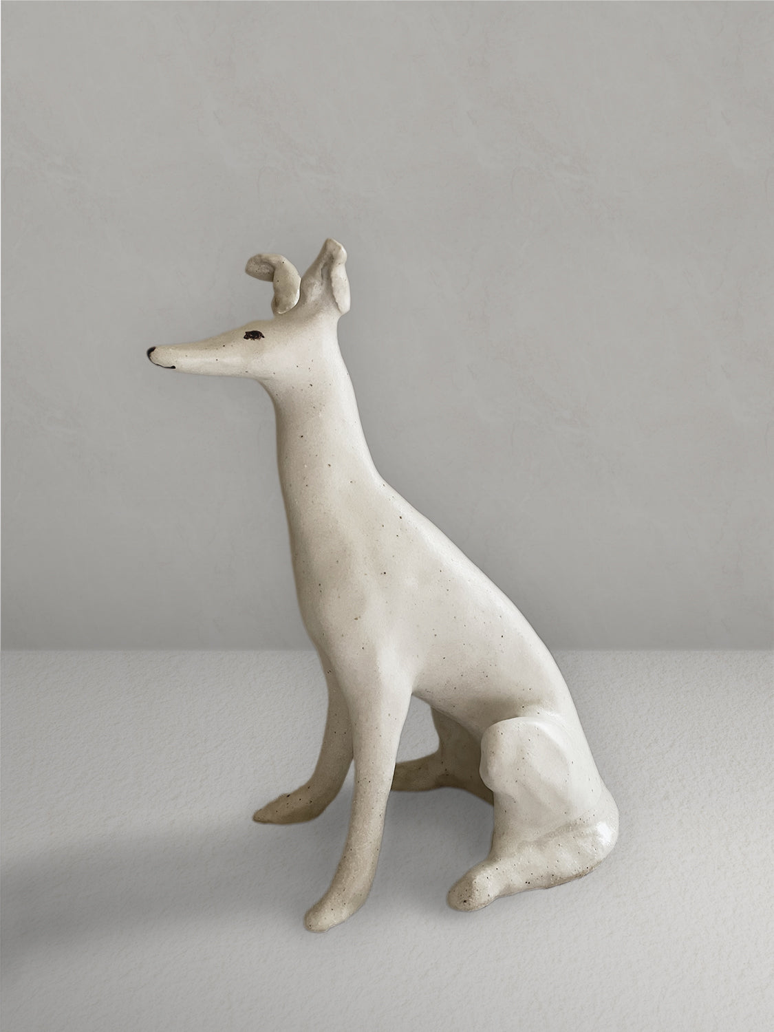 White stoneware seated hound - left side.