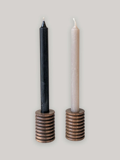 Pair of wooden candle holders in walnut with candles - front.