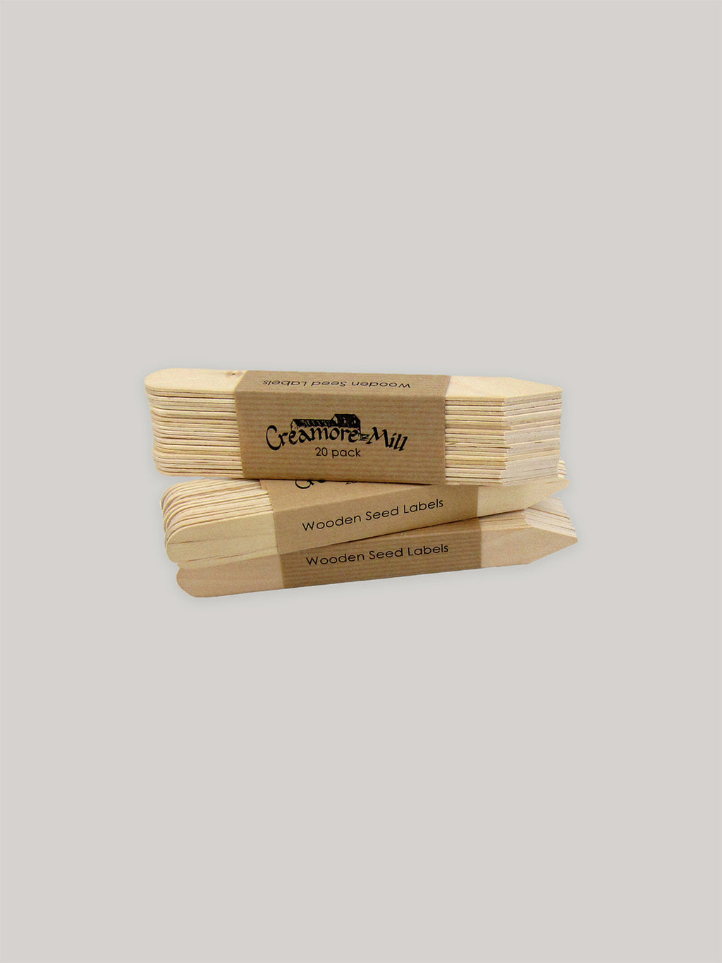 Stack of wooden seed labels with a Kraft paper label on a neutral background.