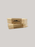Stack of wooden seed labels with a Kraft paper label on a neutral background.