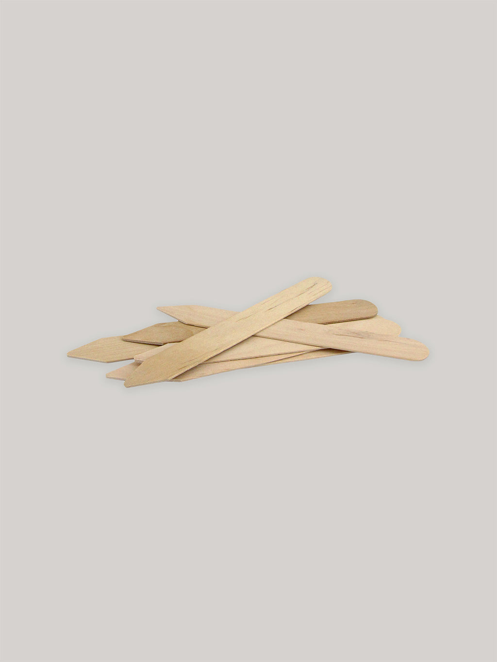 Group of wooden seed labels on a neutral background.