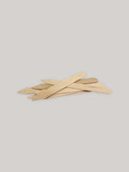Group of wooden seed labels on a neutral background.