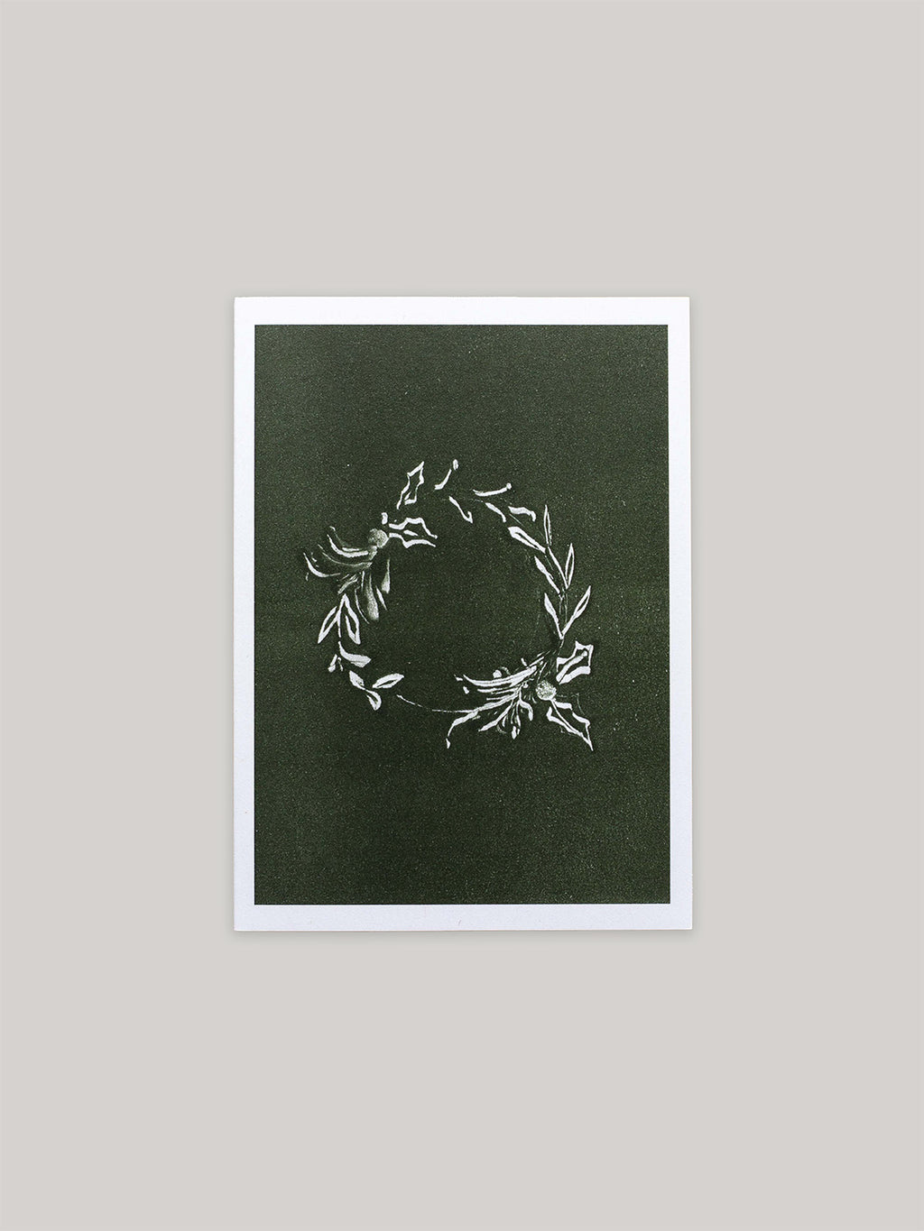 Botanical Christmas card with a leafy wreath design on a green background.