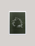 Botanical Christmas card with a leafy wreath design on a green background.
