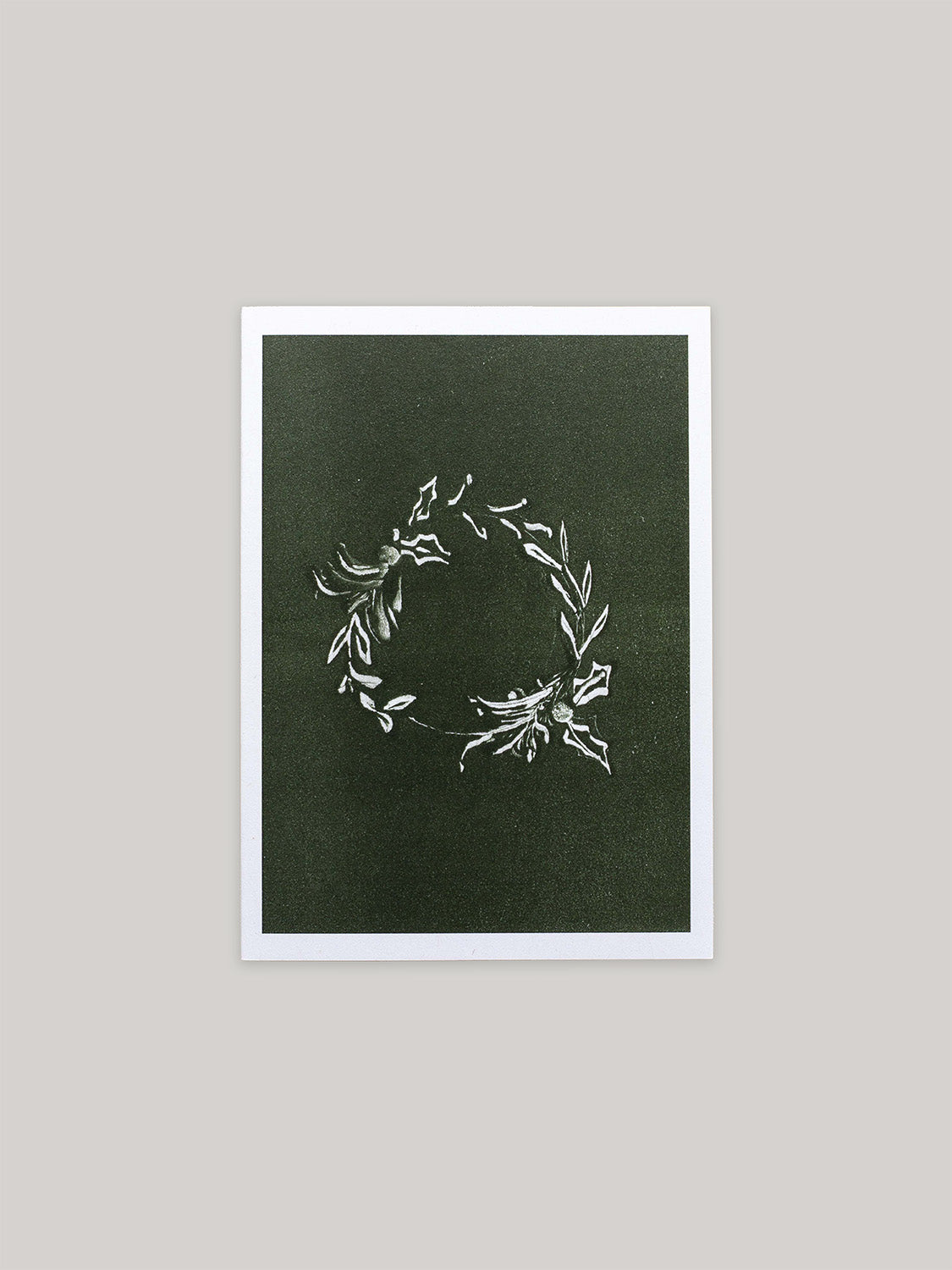 Botanical Christmas card with a leafy wreath design on a green background.
