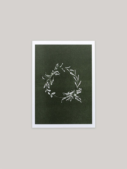 Botanical Christmas card with a leafy wreath design on a green background.