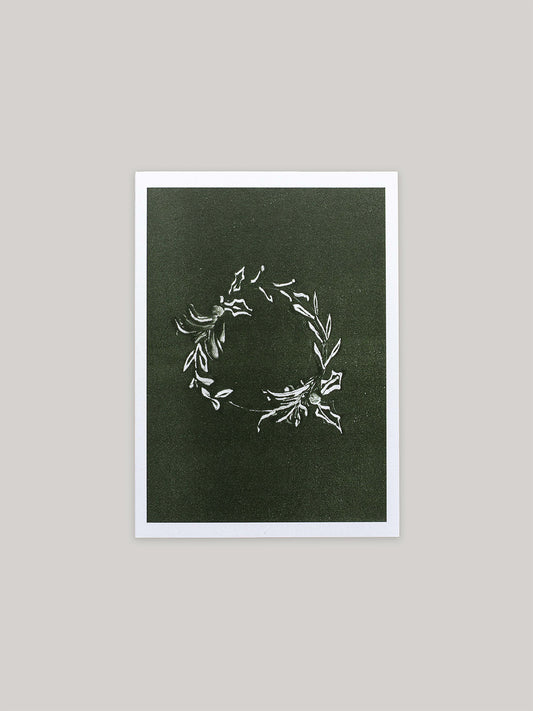 Botanical Christmas card with a leafy wreath design on a green background.