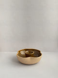 A hand-thrown ceramic candle holder in a rustic yellow ochre glaze on a neutral background - front view.