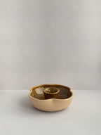 A hand-thrown ceramic candle holder in a rustic yellow ochre glaze on a neutral background - front view.